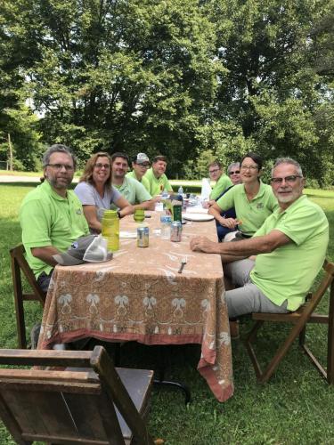 Group of workers seated around outdoor dining table